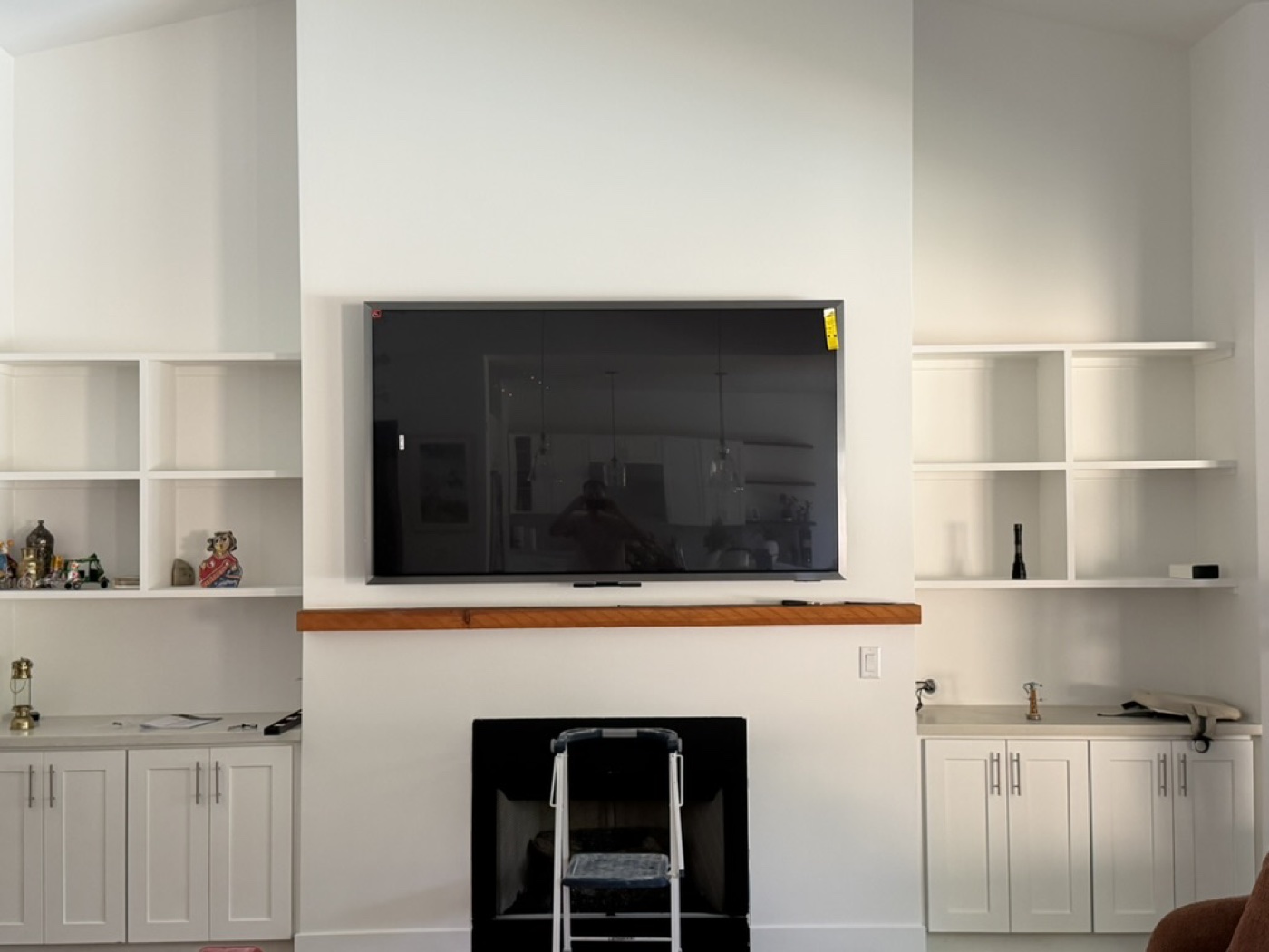 The finished 77-inch Samsung S95H installation above the mantel.