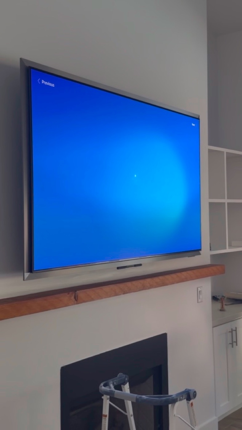 The TV is raised against the wall above the mantel.
