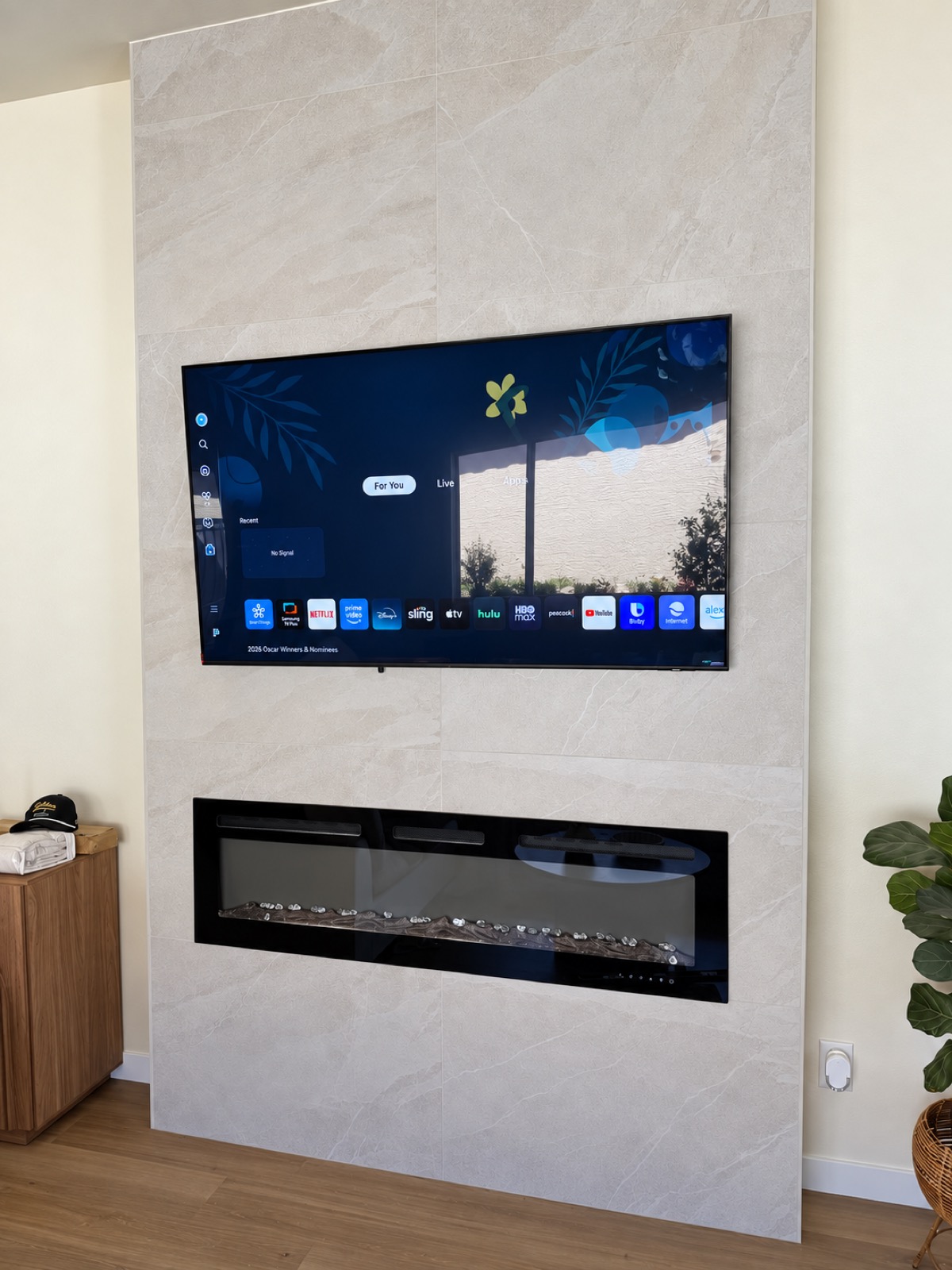 TV mounted over a large-format tiled fireplace with a clean finished wall