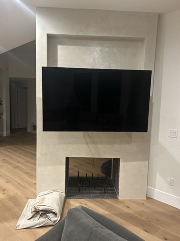 VistaMount-installed MantelMount lowering a TV to eye level above a stone fireplace