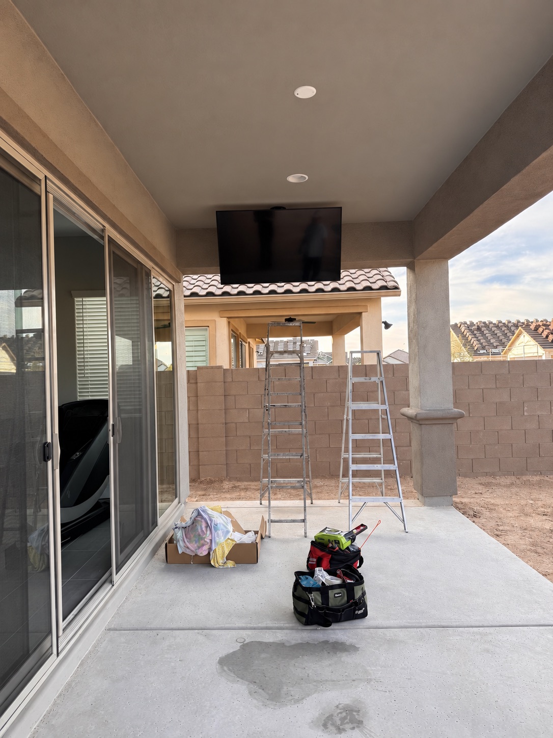 Real VistaMount covered patio ceiling-mounted TV installation in progress