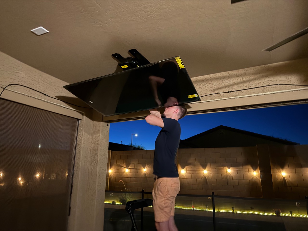 Real VistaMount technician adjusting the ceiling-mounted outdoor TV