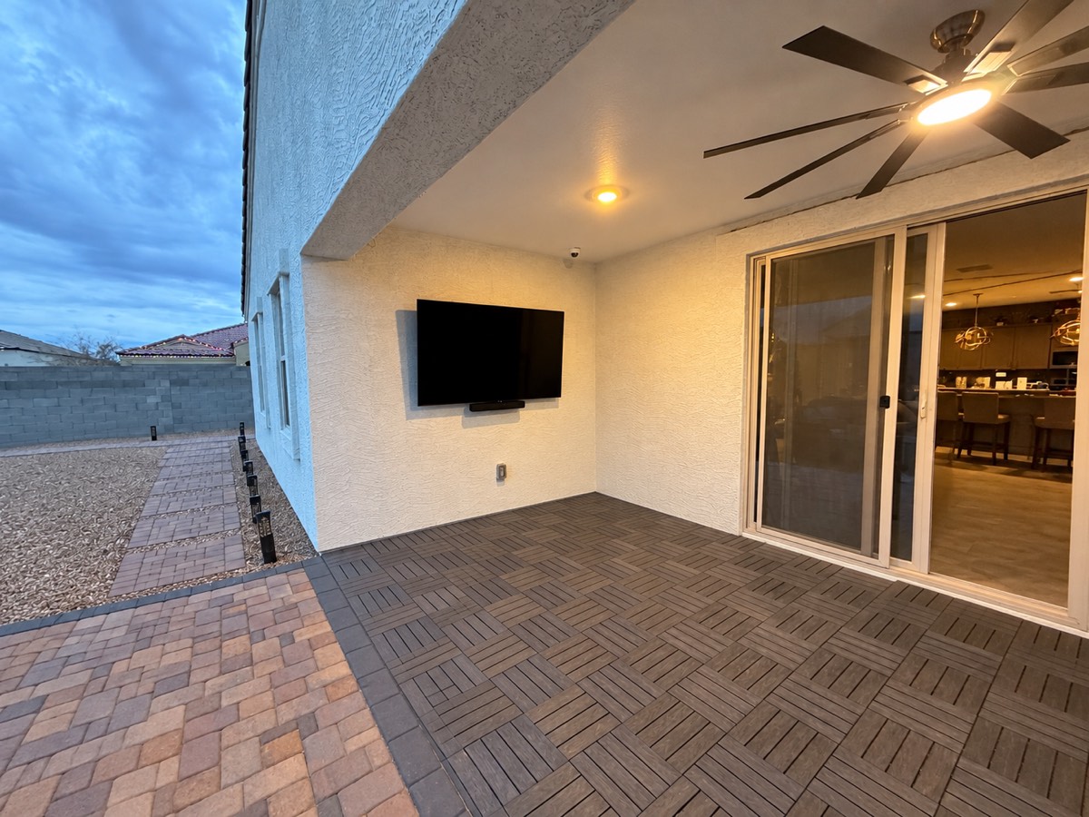 Real VistaMount finished outdoor-rated TV installation on a Phoenix stucco patio with the electrical outlet below